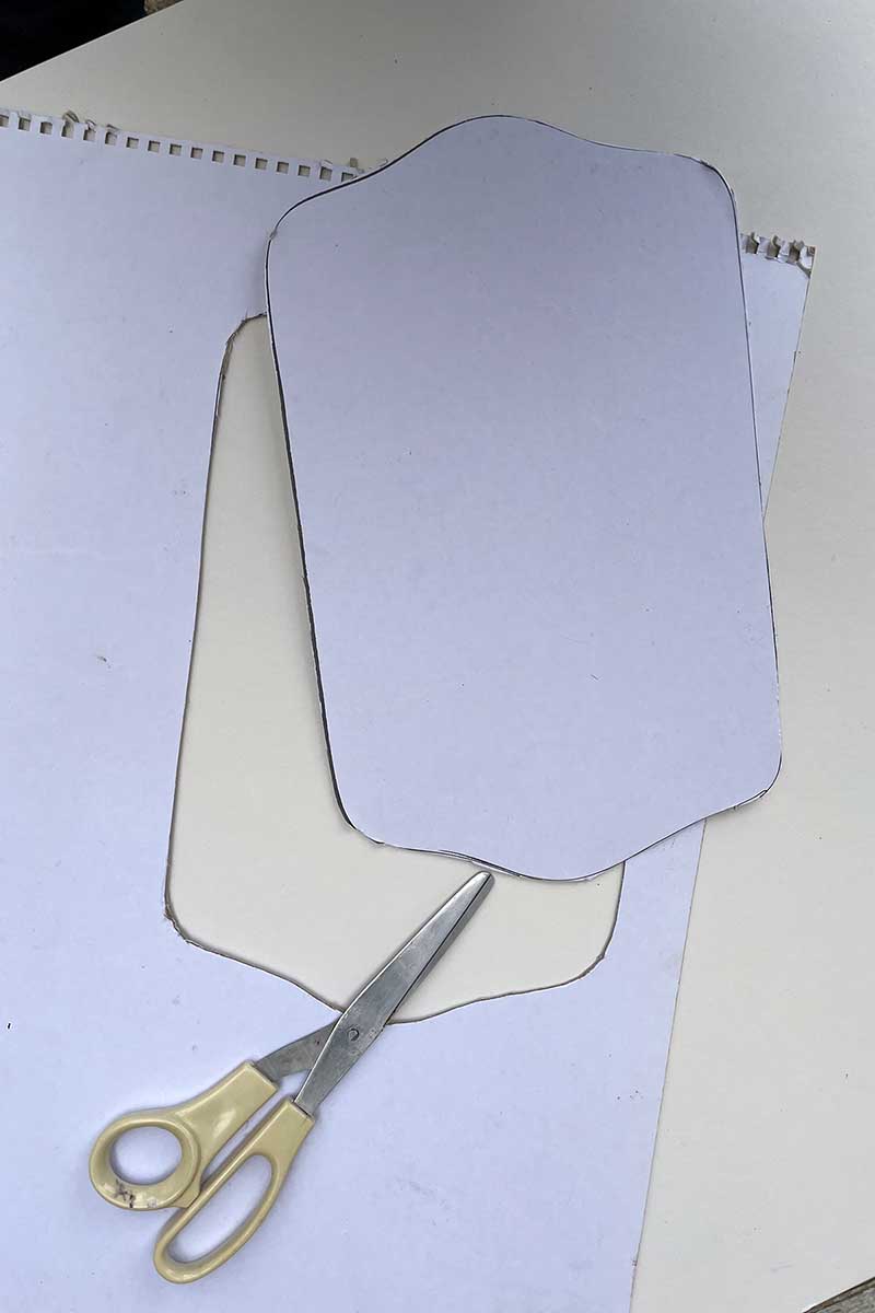 Cutting out the tray shape with scissors from the cardboard