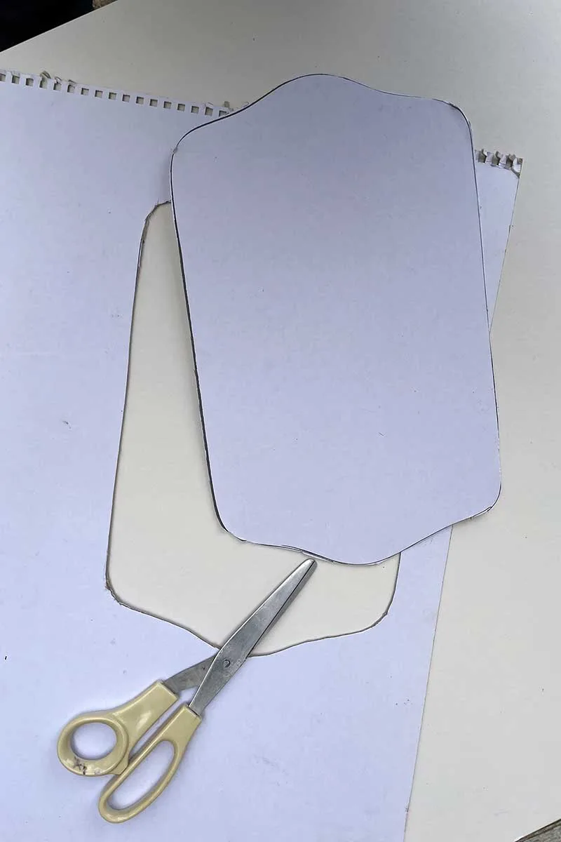 Cutting out the tray shape with scissors from the cardboard