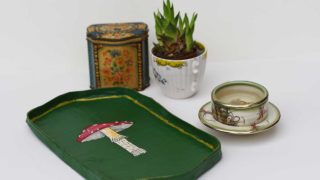 paper mache mushroom tray with tea caddy cup of tea and a plant in a tea cup