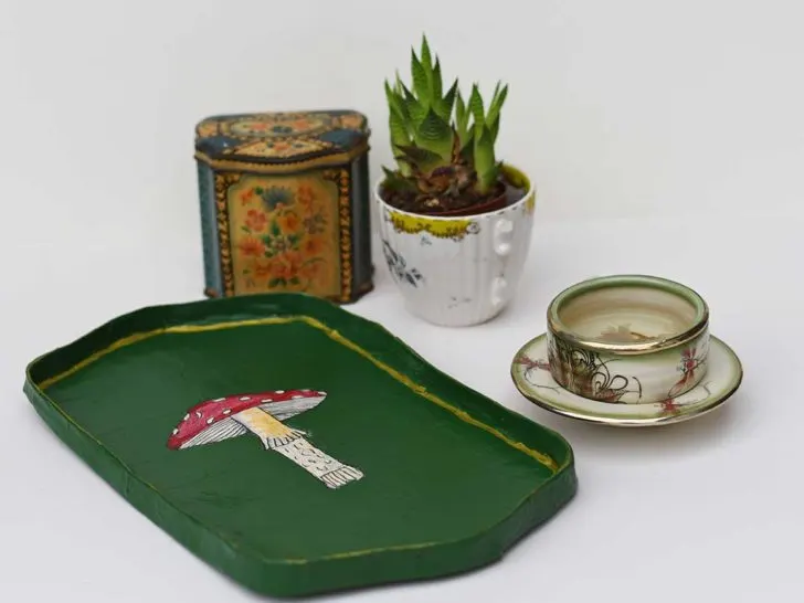 paper mache mushroom tray with tea caddy cup of tea and a plant in a tea cup