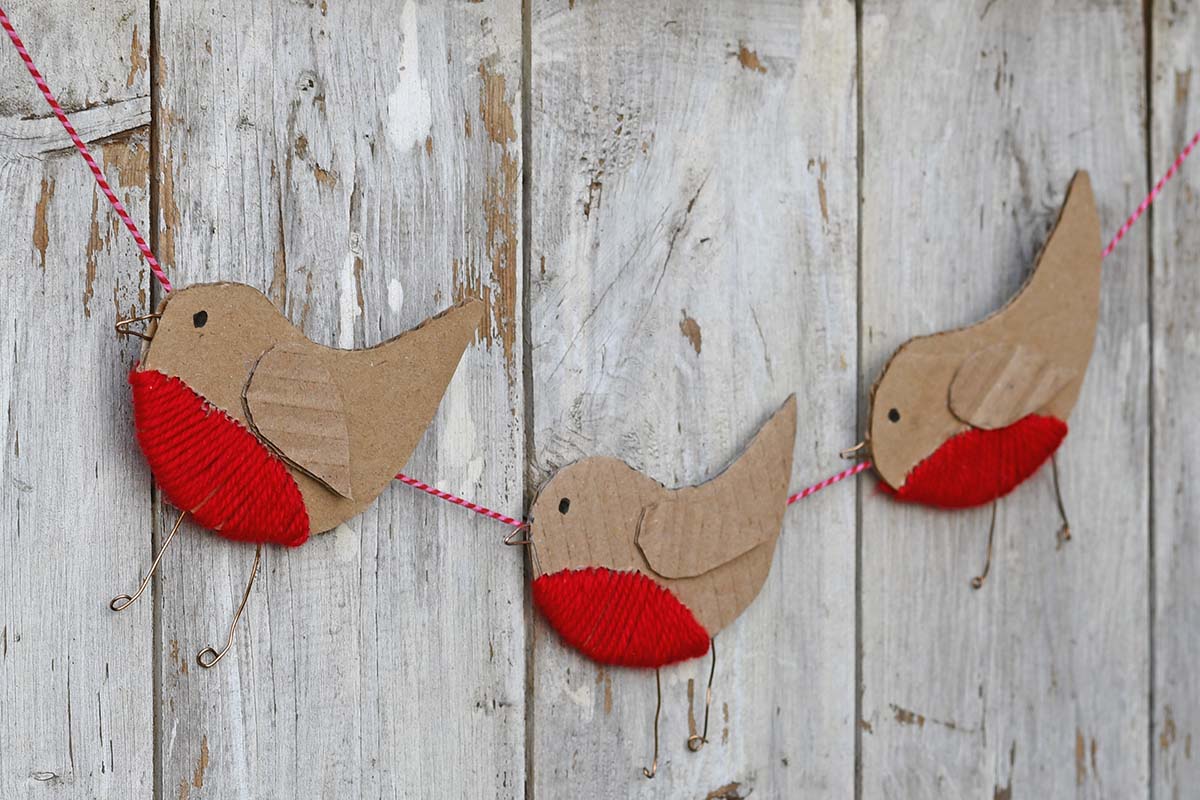 three cardboard robin ornaments in a garland