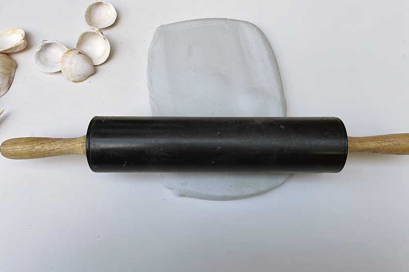 rolling out the air dry clay into a paint palette shape