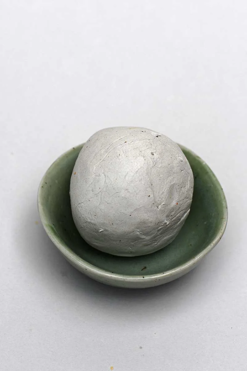 pushing clay into the bowl