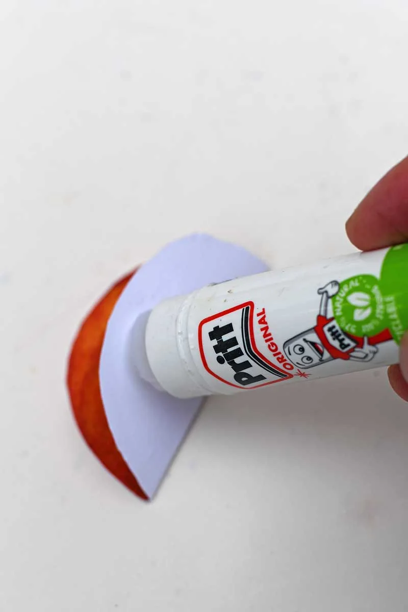 adding glue to paper with glue stick