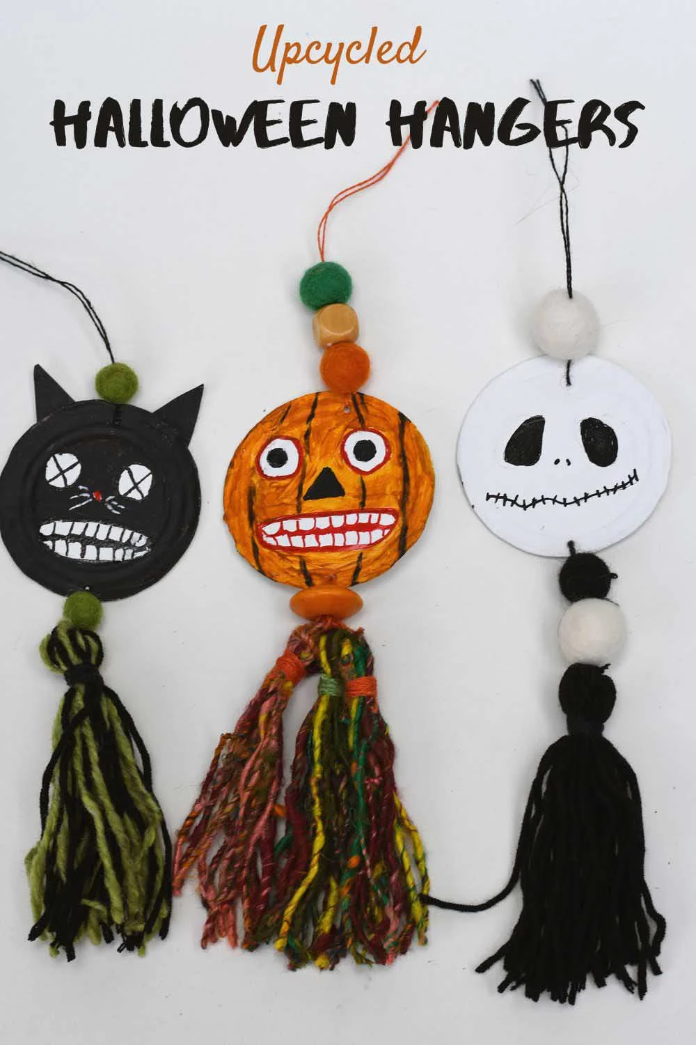 Upcycled halloween hangers made from tin cans, Spooky black cat, scary pumpkin heads and Jack Skellington.