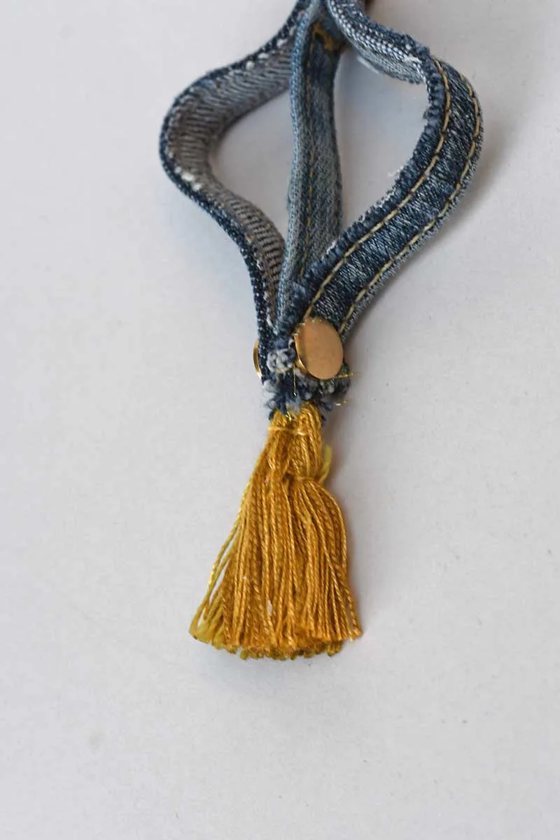 Adding tassel to the bottom of the denim seam ornaments