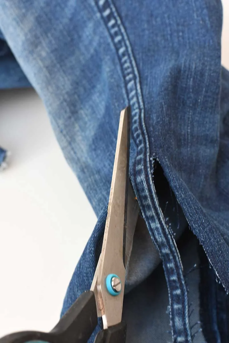 cutting the seams from a pair of jeans