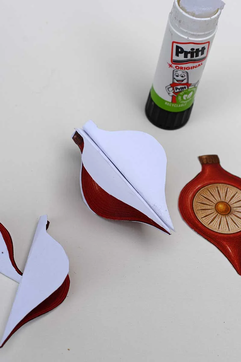 Gluing the red Shiny Brite paper ornament pieces together.