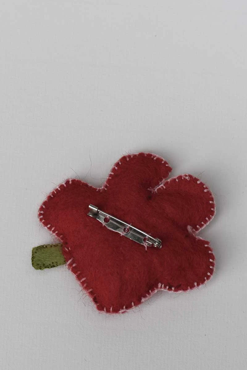 Stitching the brooch pin on the back of the felt poppy