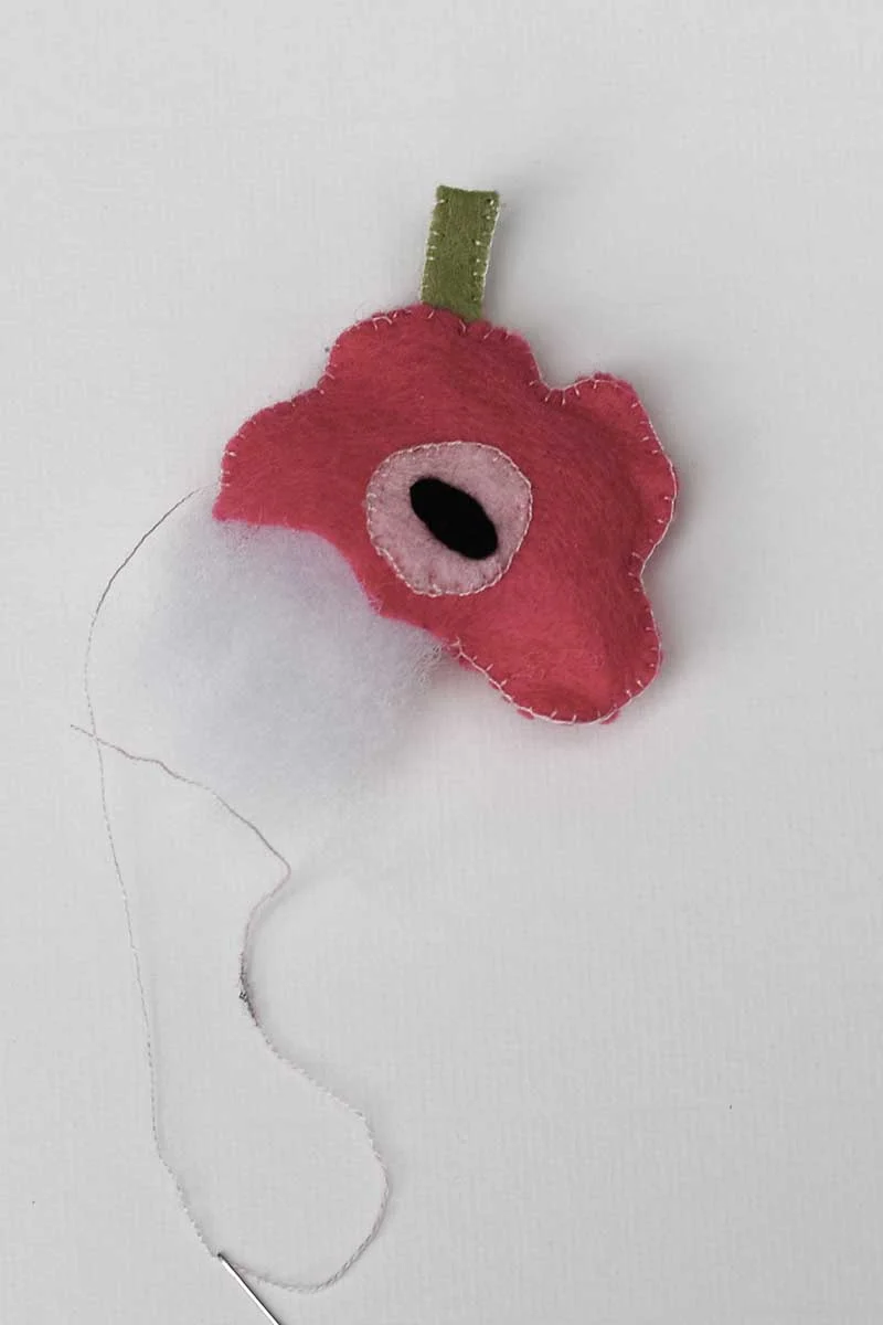 stuffing the felt poppy brooch with fiber fil