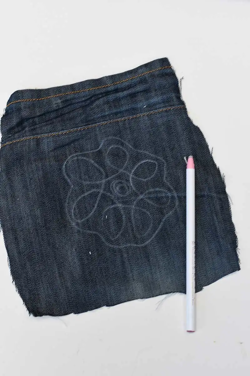 Drawing squiggle design on denim with chalk pencil