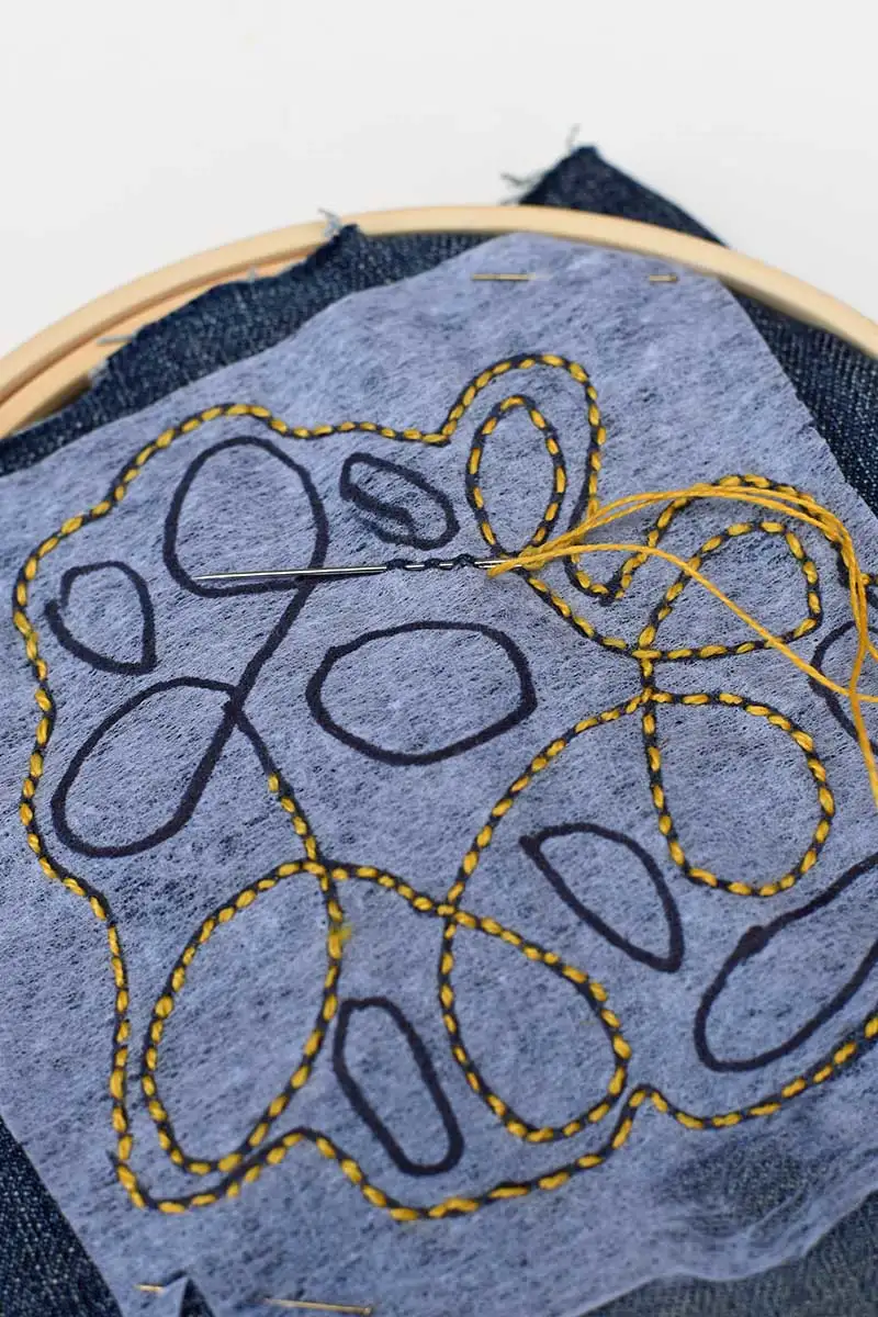 stitchin in yellow on denim following squggles