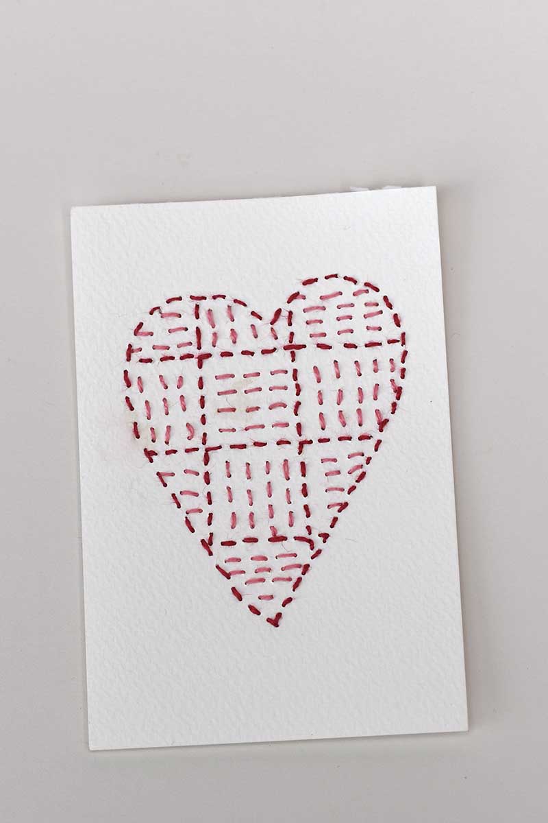 Sashiko paper heart embroidery striped pattern in two coloured threads.