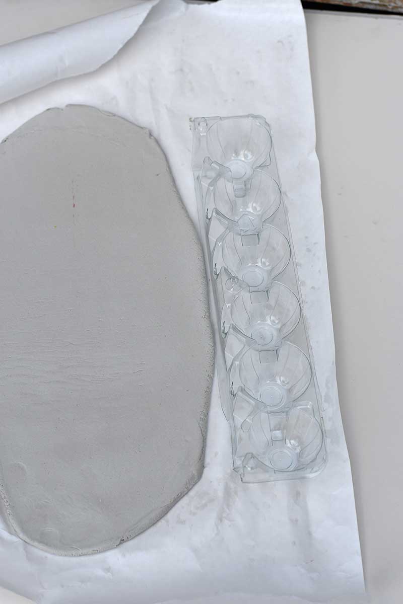 rolling out the clay with egg carton strip