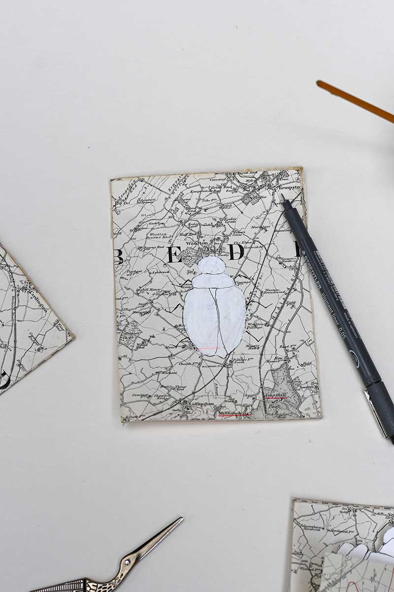 Drawing in the details on the maps with a pen