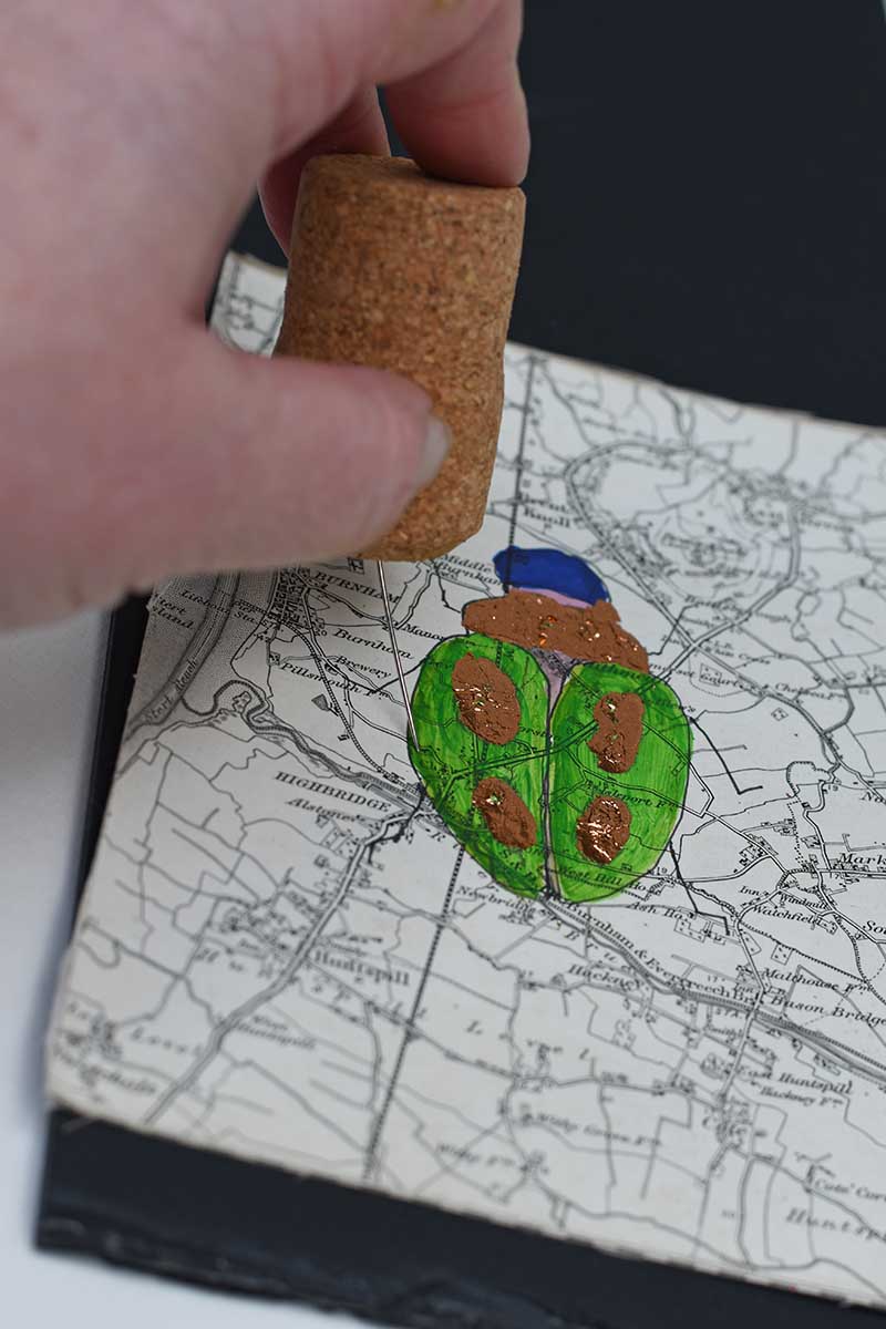 punching holes in the map paper for stitching