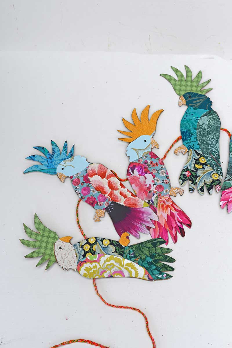 Making a garland with colourful upcycled paper cockatoos