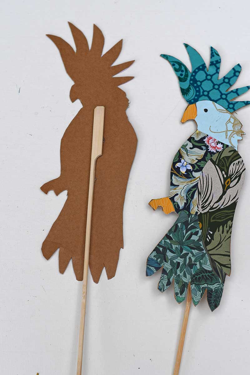 Gluing wooden stick to back of the paper cockatoo to make bird craft pot decorations