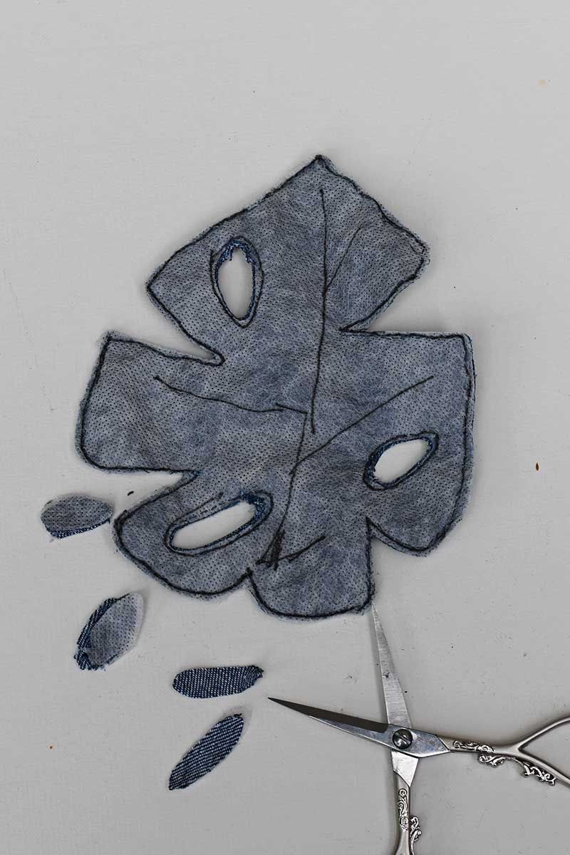cutting the holes in the Monstera denim leaf