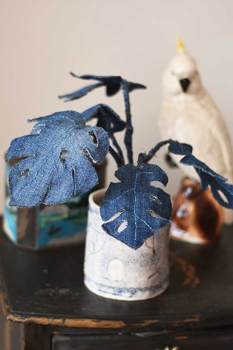 Denim monstera plant with ceramic cockatoo in the background