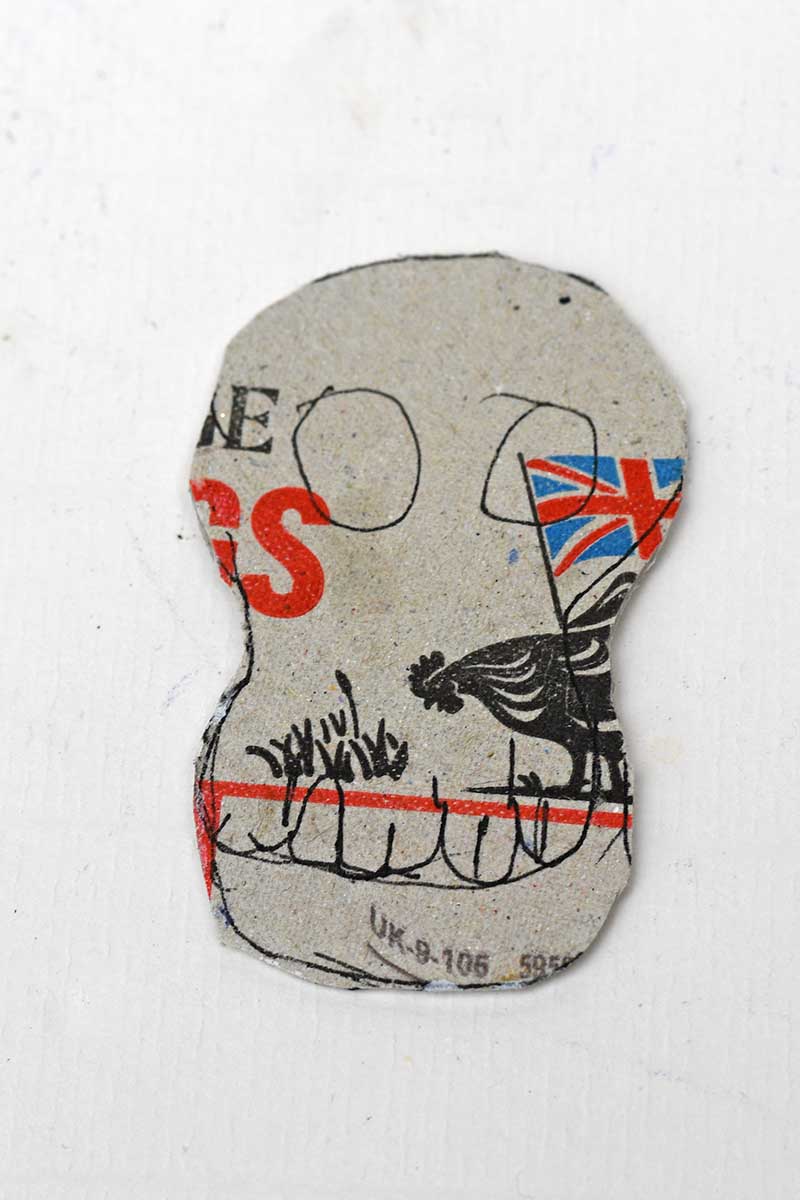cutting out a cardboard skull shape from an egg carton lid