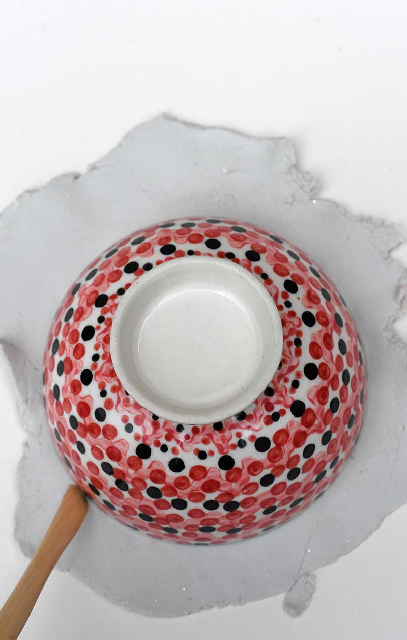 cutting out clay round a bowl shape