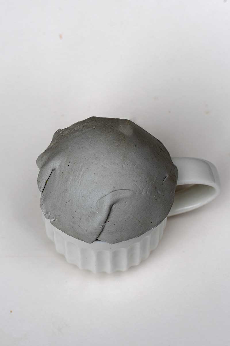 clay shaping over round mould